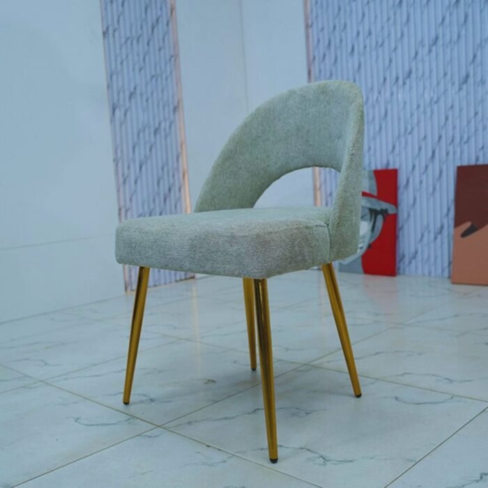 Chaise moderne grise avec dossier arrondi ajouré et quatre pieds fins dorés.